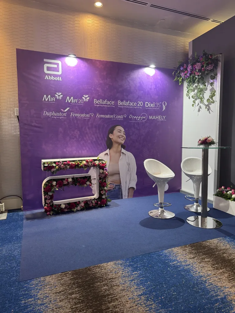 Stand de Perfiles (Octanorm) para Abbott en congreso de Panamá con mesa alta y decoración floral.